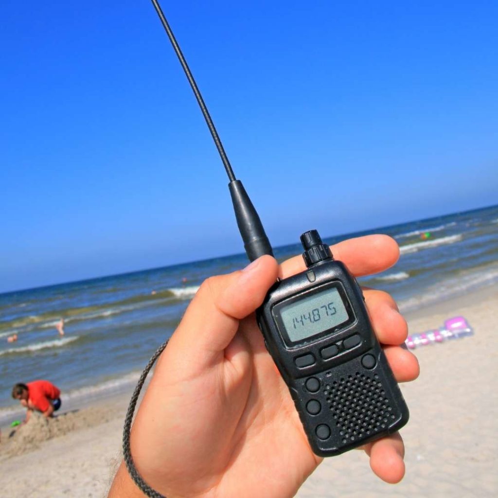 Man holding small walkie talkie at the beach