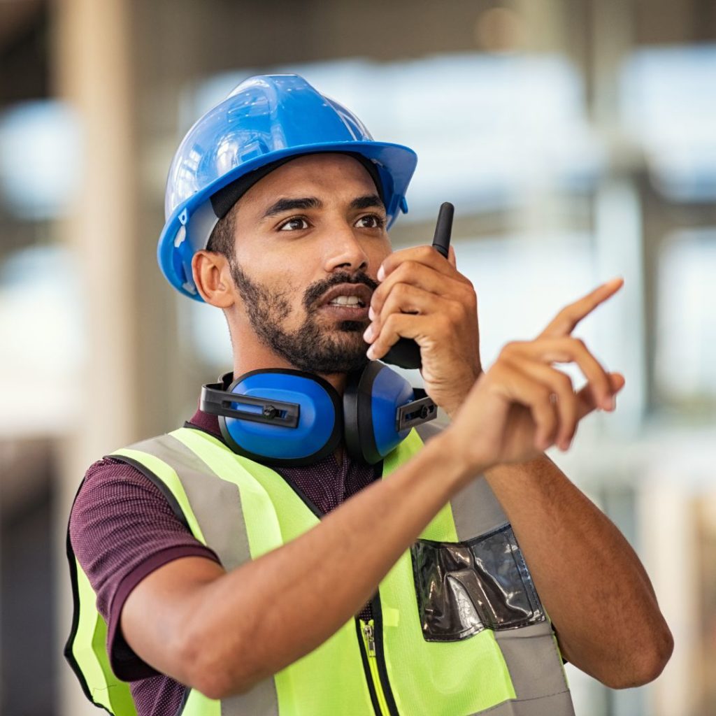 a construction worker talking into a walkie talkie