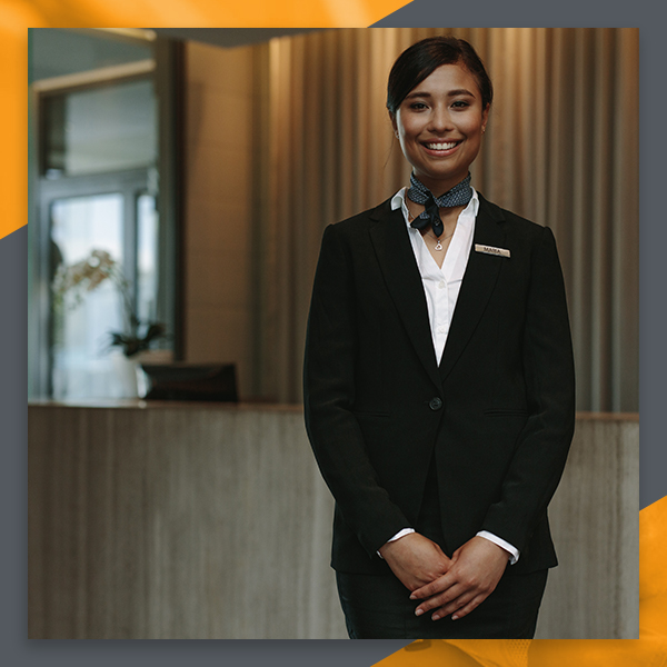 Hotel receptionist smiling in front of front desk