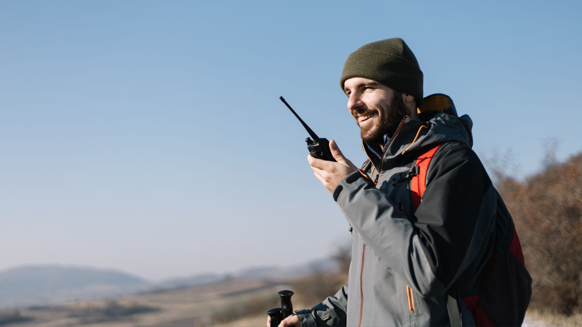 person on mountain top with two way radio