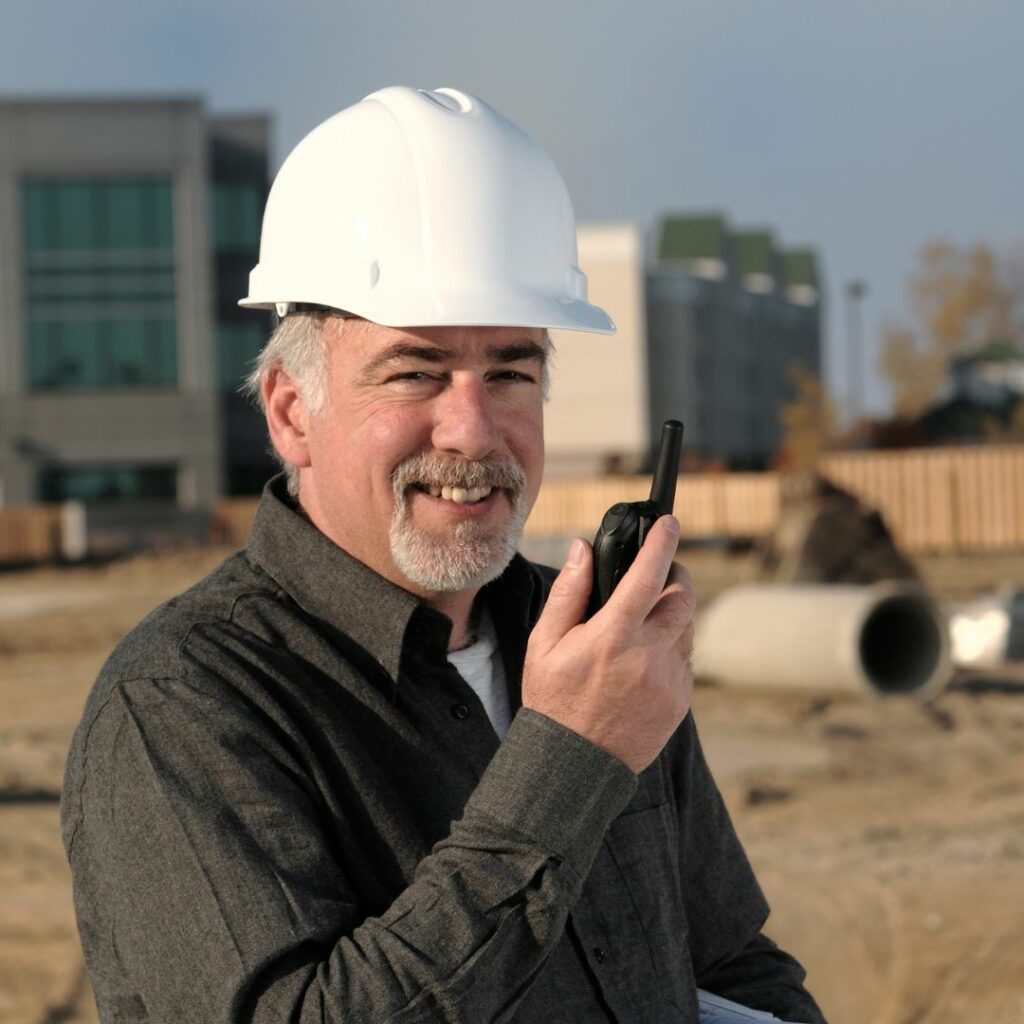 man on construction site holding radio