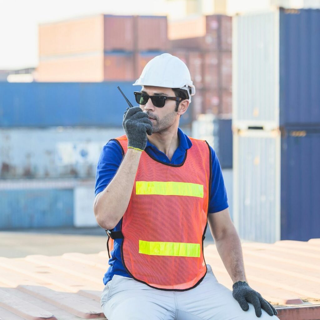 Construction worker sitting and talking into a radio