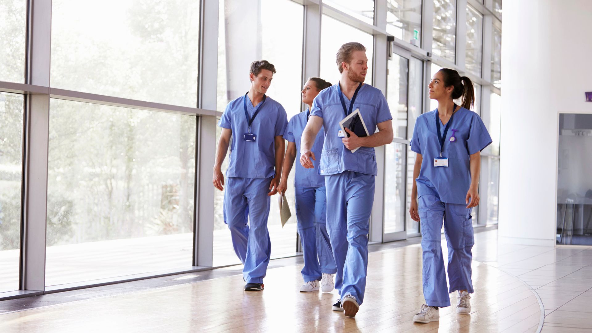 team of nurses walking down the hall while having a conversation.