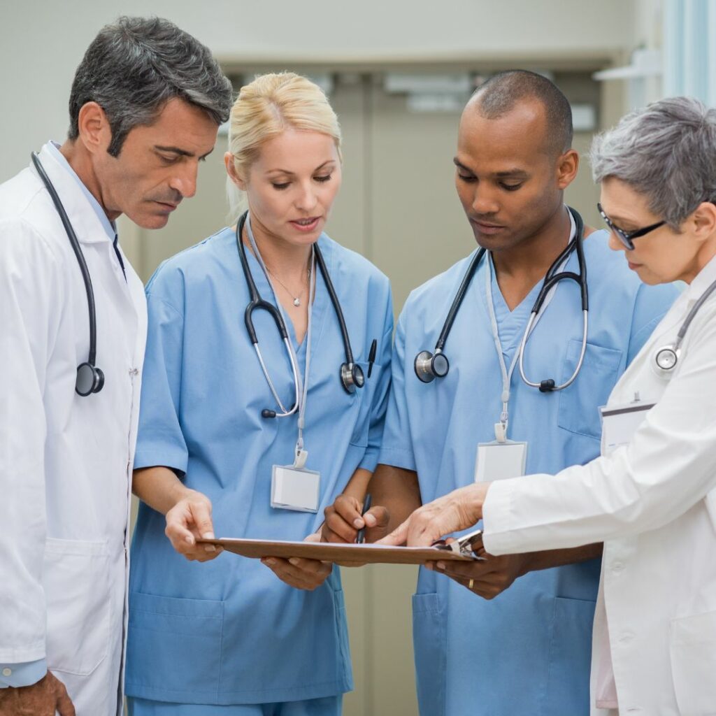 Team of nurses and doctors discussing a patient's chart. 