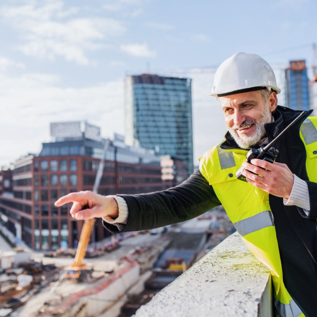 construction working pointing while on a two way radio