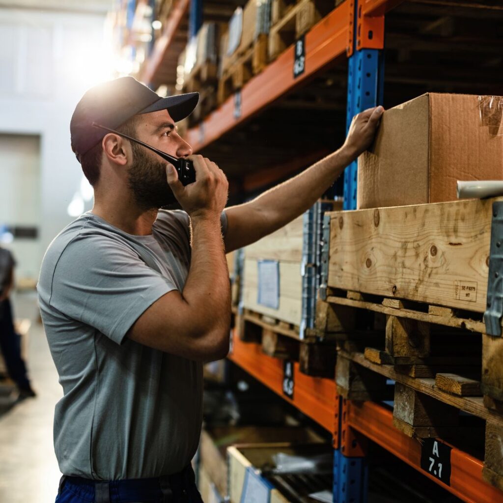 man in a warehouse with a two way radio