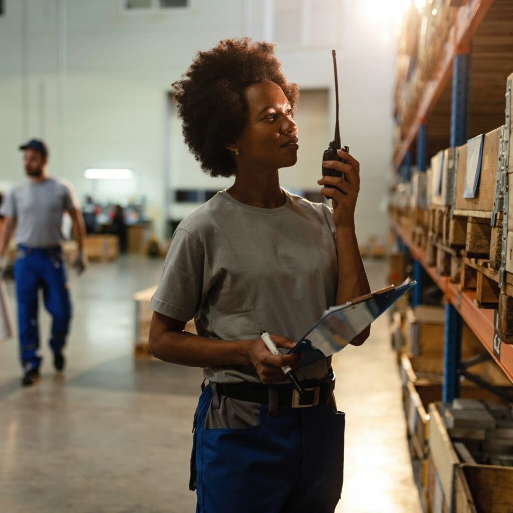 woman in a warehouse with a two way radio